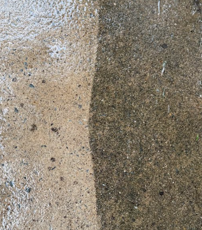 Concrete patio showing clean side after power washing next to dirty side before